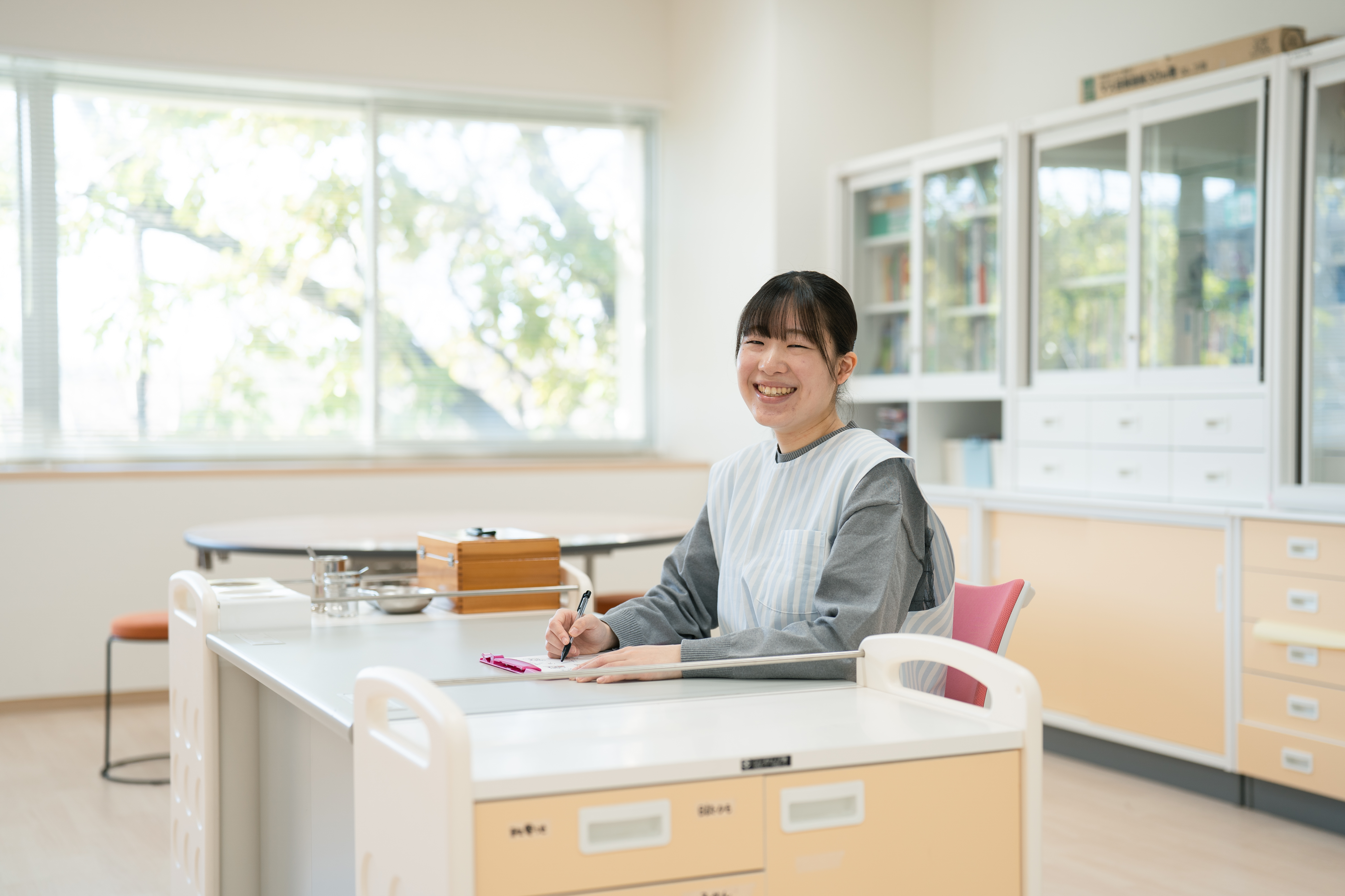 保健室で記録を確認する養護教諭